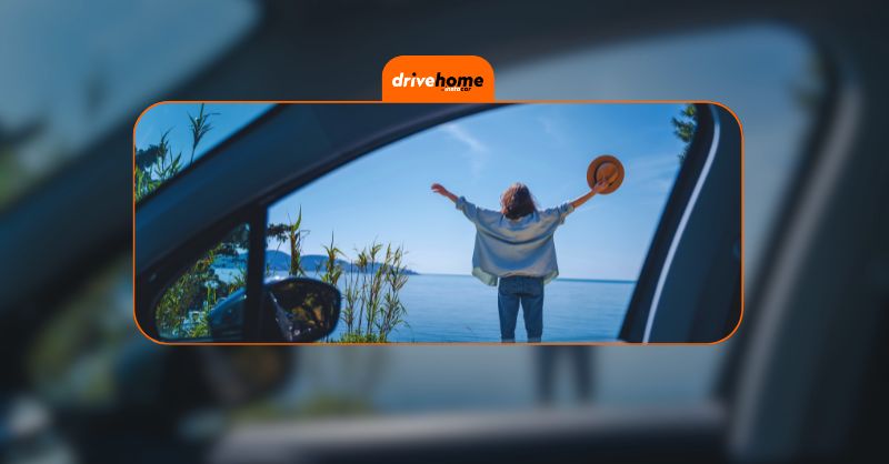 a happy woman by the sea seen from her car's window